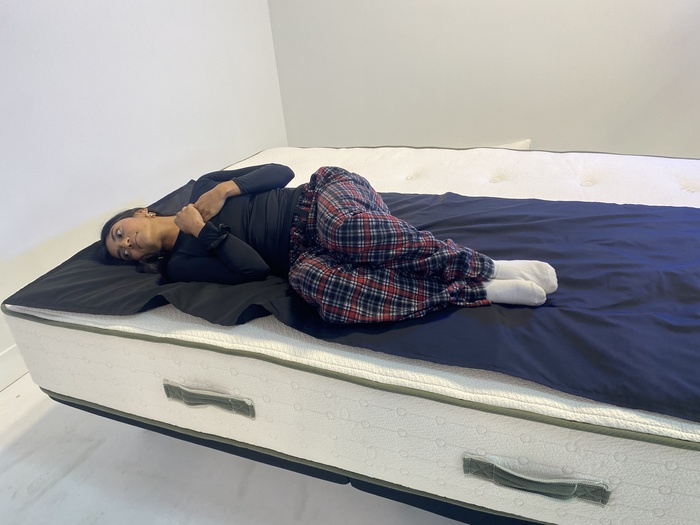 A woman lying on a pressure mat (a specialized mat that reads pressure buildup on a mattress) on top of the Avocado Green.