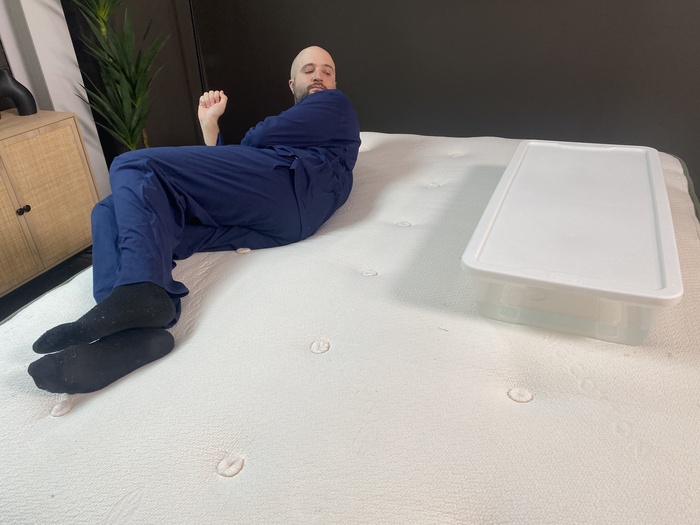 A man lying on the Avocado Green next to a large bin of water. He's rolling back and forth to see if the water moves.