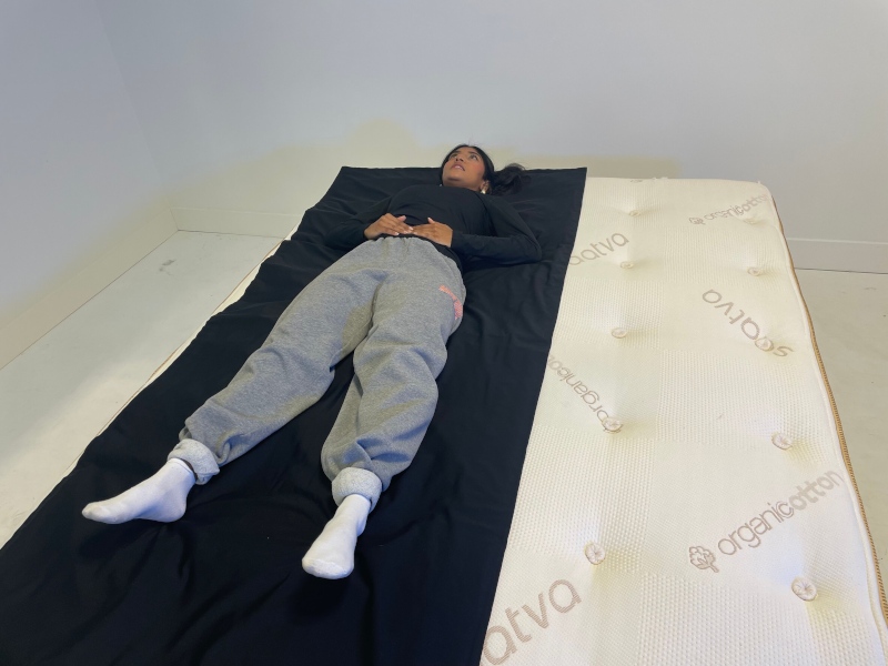 A person lying on a pressure mat on a Saatva Latex Hybrid mattress.