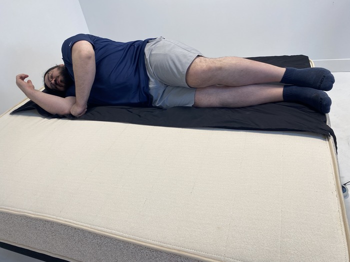 A man lying on his side on the Birch Natural mattress.