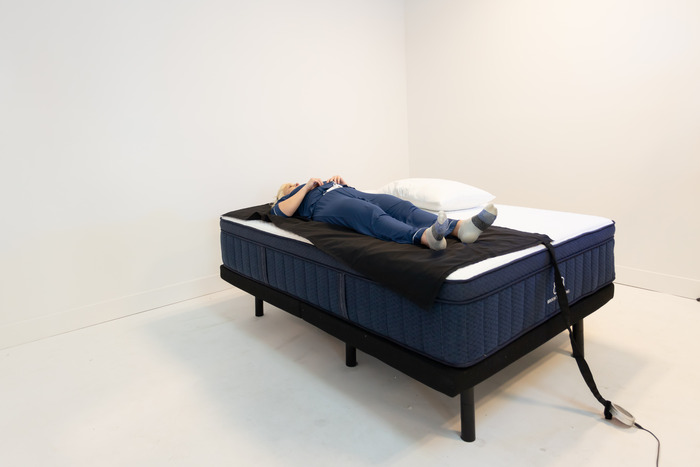 A woman lying on her back on the Brooklyn Bedding Aurora Luxe mattress.