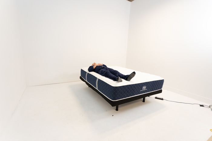 A man lying on his back on the Brooklyn Bedding Signature Hybrid.