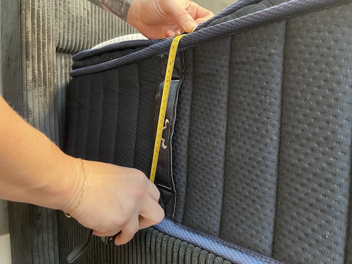 A closeup of someone using a tape measure to measure the height of the DreamCloud Premier Hybrid.