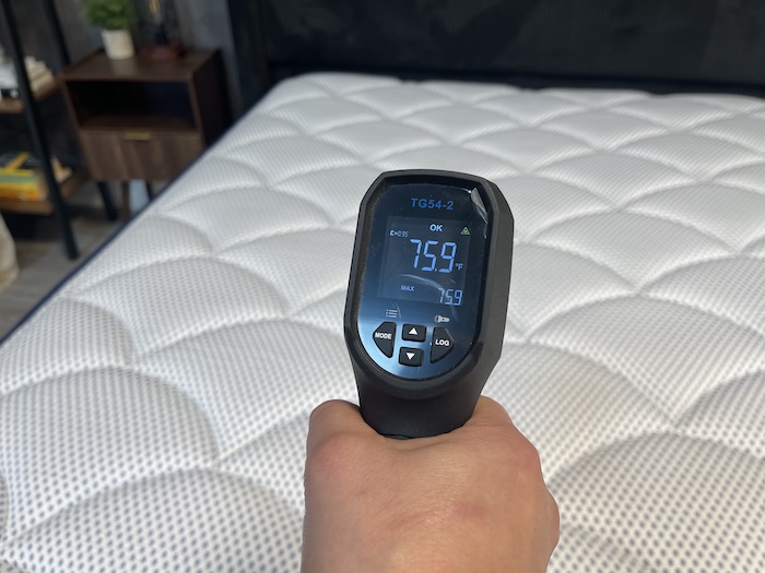 A closeup of someone reading the DreamCloud Premier Hybrid's neutral temperature with a thermal gun. The screen reads 75.9 degrees.