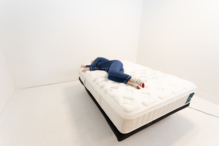 A woman lying on her side on the Leesa Sapira Chill Hybrid mattress.