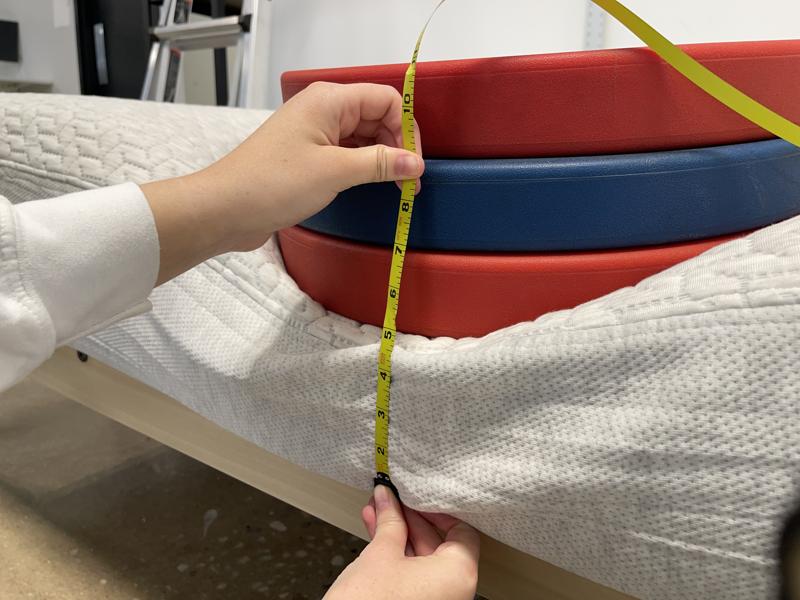 Measuring weight plates on the edge of the Tuft & Needle Mattress