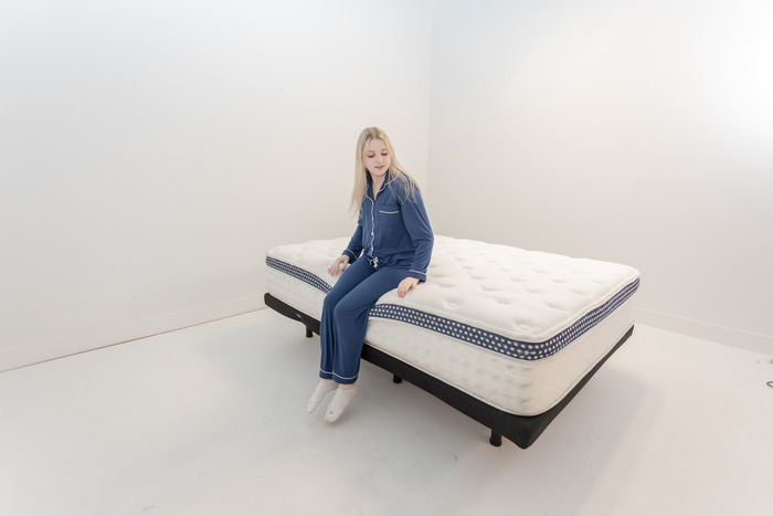 A woman sitting on the edge of the WinkBed mattress.