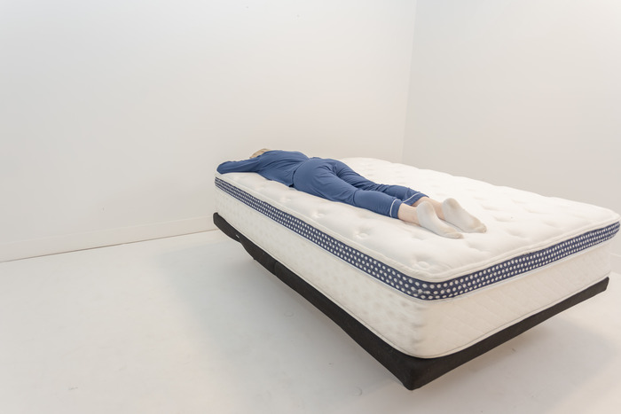 A woman lying on her stomach on the WinkBed.