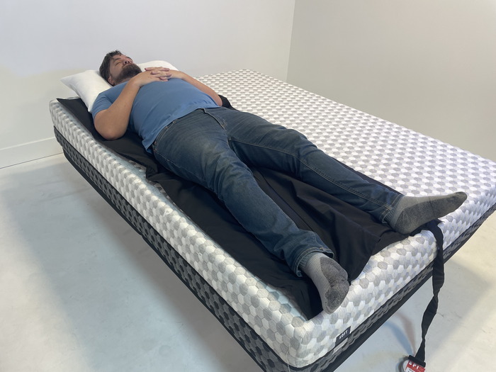 A man lying on his back on the soft side of the Layla mattress.