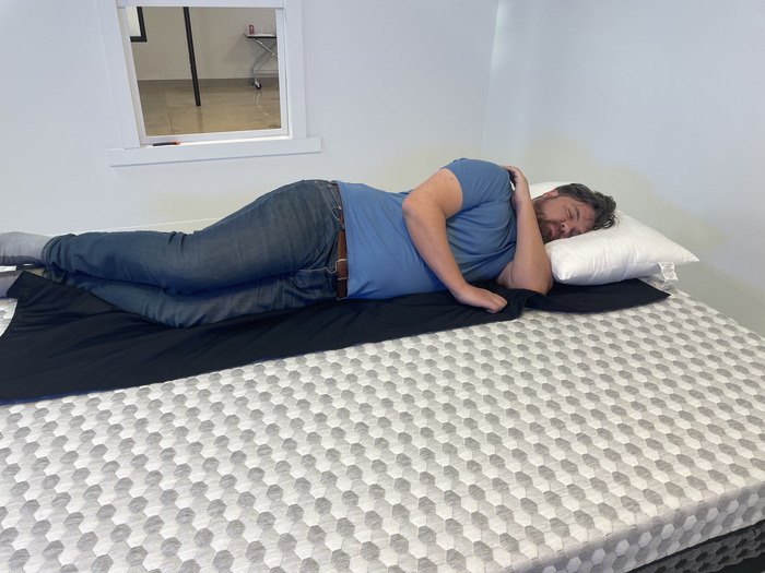 A man lying on his side on the soft side of the Layla mattress.