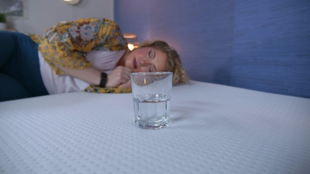 Nichole performing the water test on the Zinus Green Tea Memory Foam mattress.