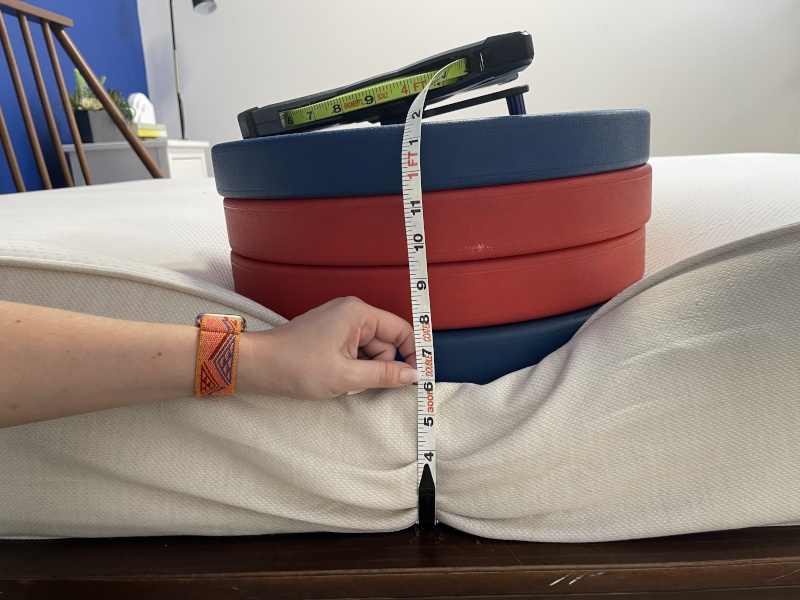 Our tester measures the deflection of weight plates along the edge of a Boring Hybrid Mattress.