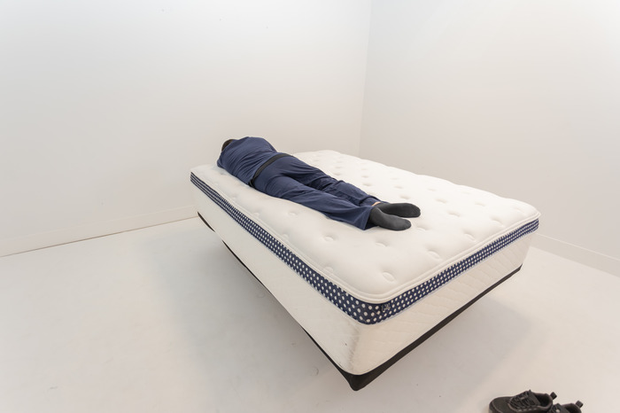 A man lying on the WinkBed Plus in the stomach-sleeping position.